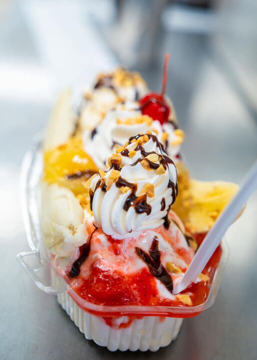A loaded sundae with whipped cream, strawberries, chocolate, peanuts and a cherry