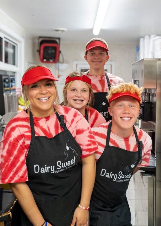 Crew members in red visors and Dairy Sweet aprons in the kitchen