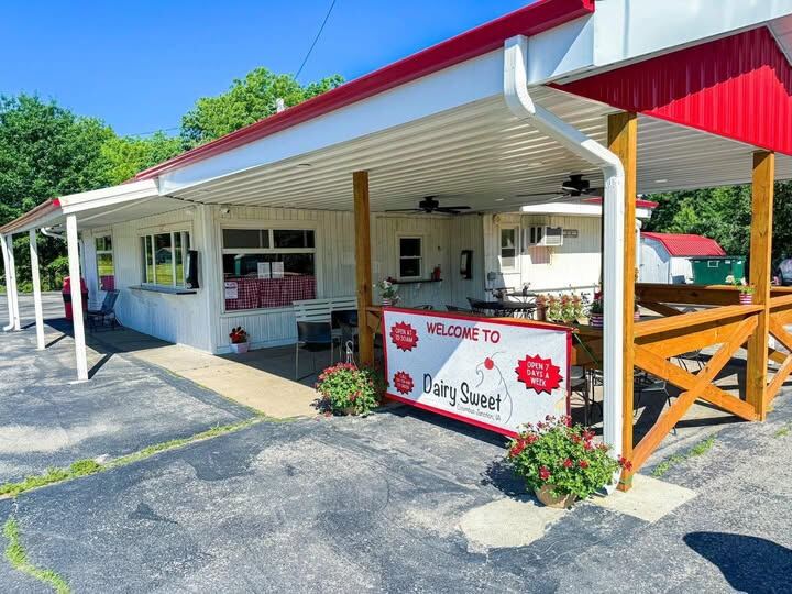 The Dairy Sweet building with its red roof, covered patio and welcome sign